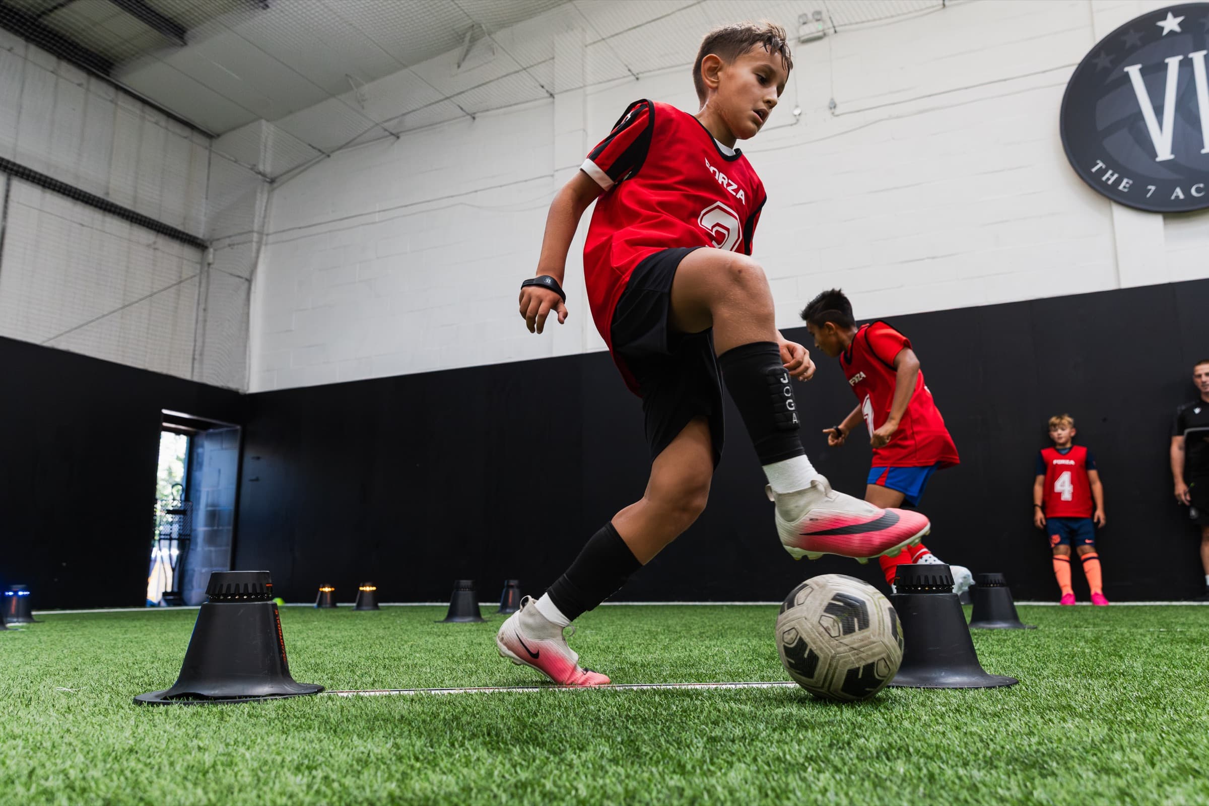 A player dribbling through cones at a 7 Academy testing session